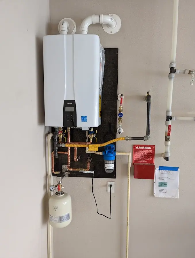 Professional plumber installing copper piping in a Greendale home